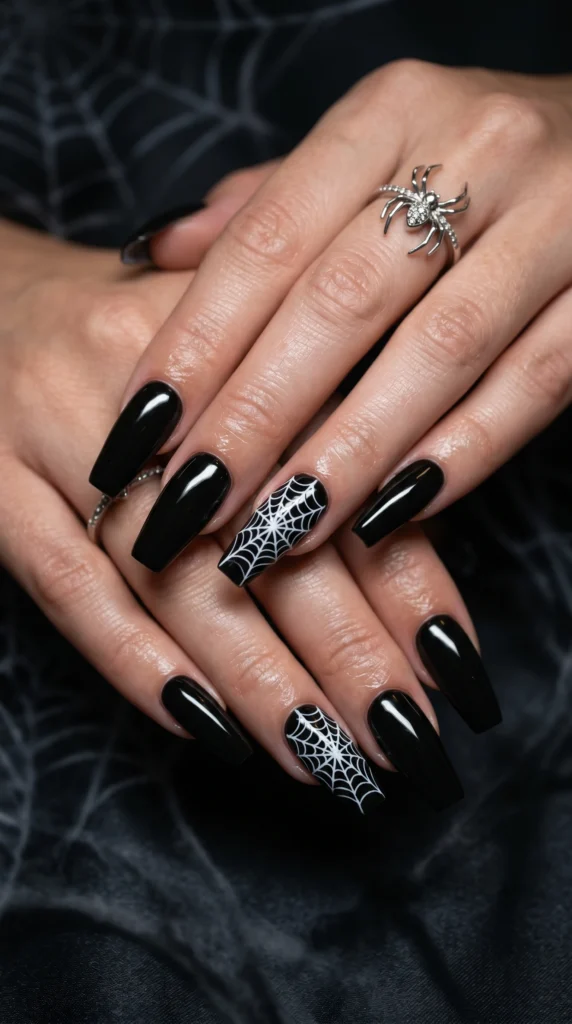 Coffin nails in glossy black with delicate white spiderweb art accent nails edgy baddie year-round