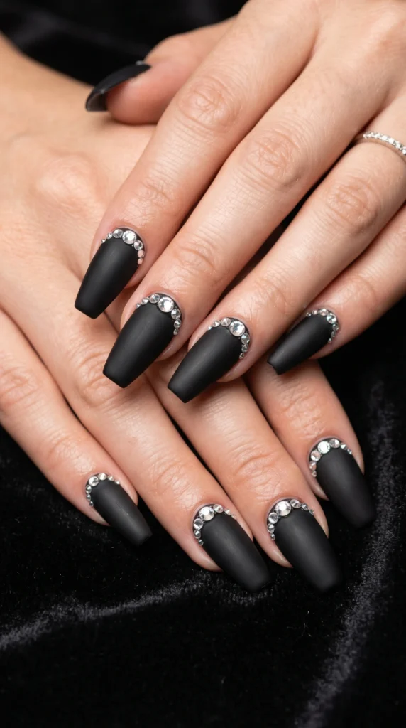 Coffin nails in matte black with graduated clear rhinestone half moon arc at cuticle baddie glamour