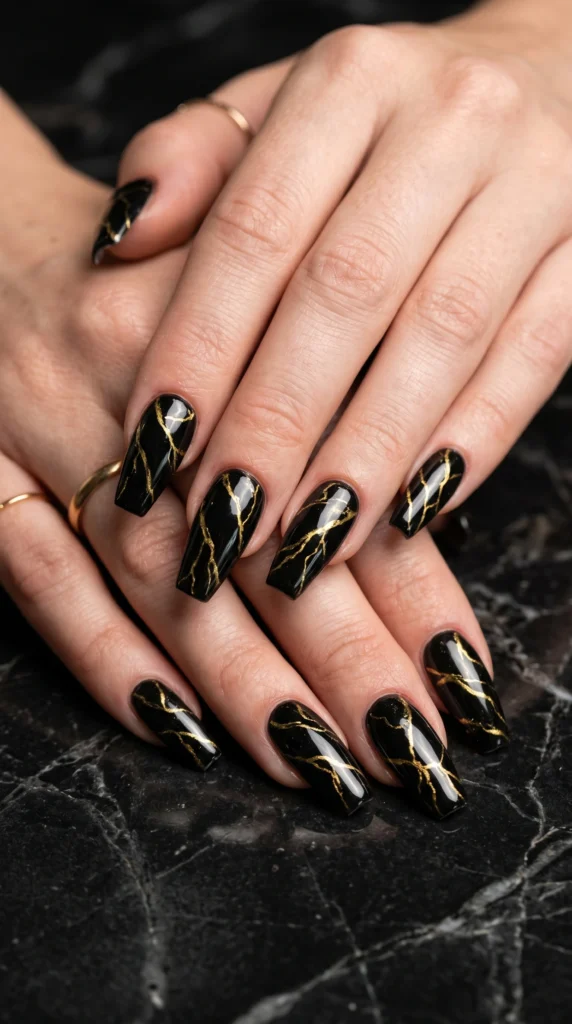 Coffin nails with black marble art gold vein lines glossy finish like polished black and gold marble stone