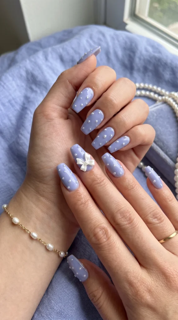 Coffin nails in periwinkle blue with scattered micro-pearl art and satin bow charm accent dreamy stunning