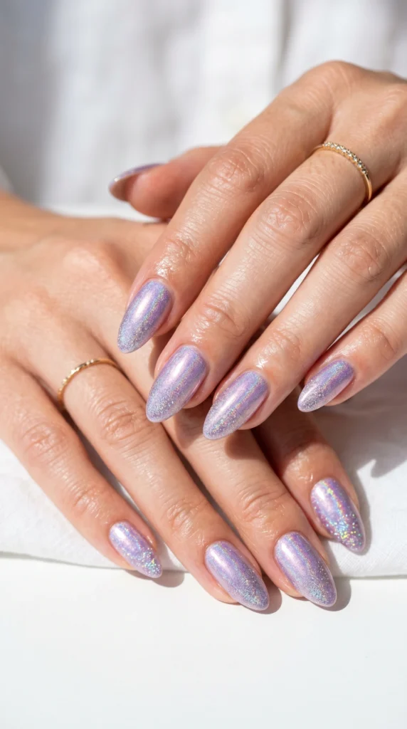 Almond nails in lilac holographic shimmer with glitter fade tips, magical iridescent color-shifting nail art