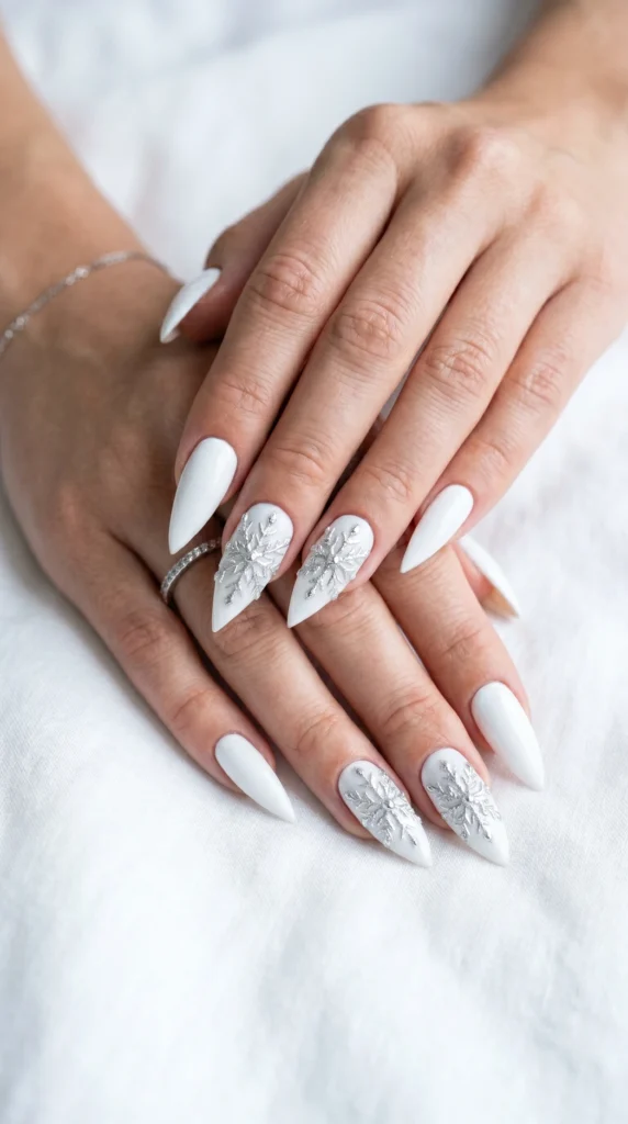 Long stiletto icy white nails with chrome powder snowflake accent detail, winter soft girl nail design 2026