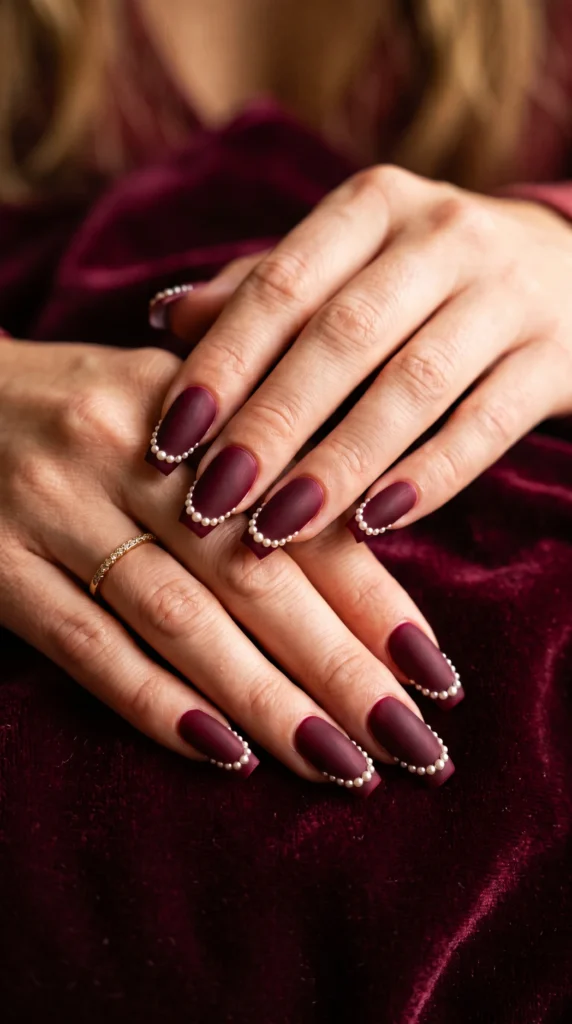 Coffin nails deep burgundy velvet matte with micro-pearl row tip detail elegant fall autumn mood