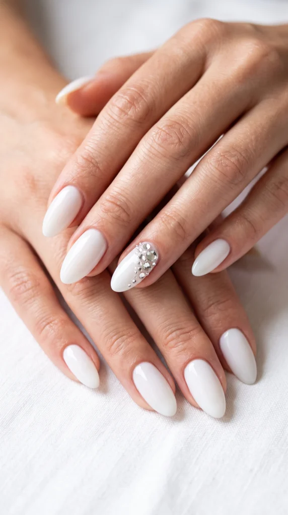 A person's hand with a white nail and a diamond on it.