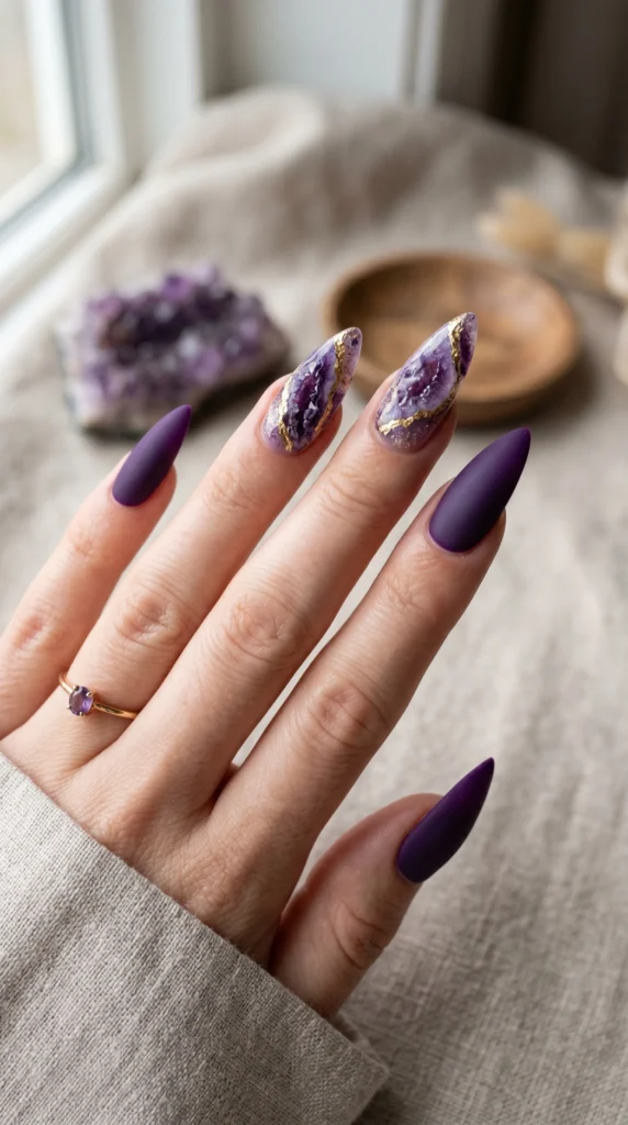 Stiletto nails with amethyst geode crystal art, crystalline clusters, and gold foil veining