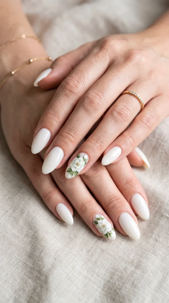 A woman with white nails and a flower design on one of them.