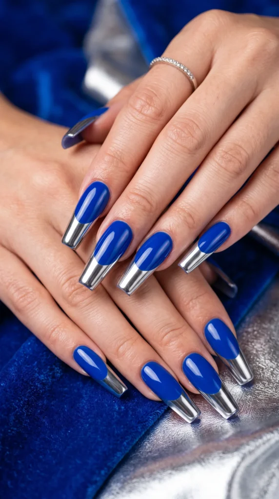 A person's hand with blue nail polish and silver nail polish.