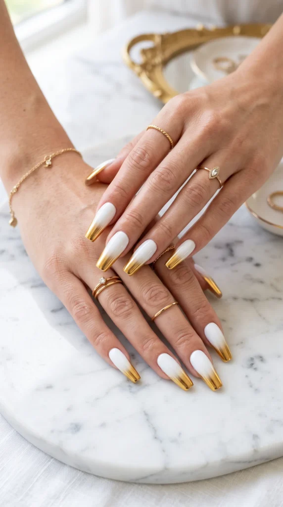 A woman with white and gold nail polish on her fingers.