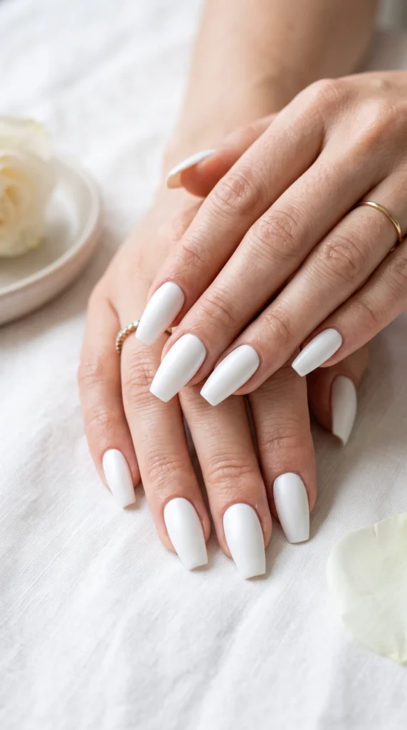 A woman's hand with white nail polish.