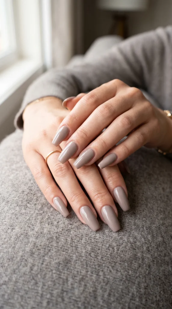 A woman with light brown nail polish on her fingers.