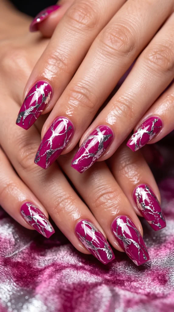 A person's hand with purple nail polish and a design on the nails.