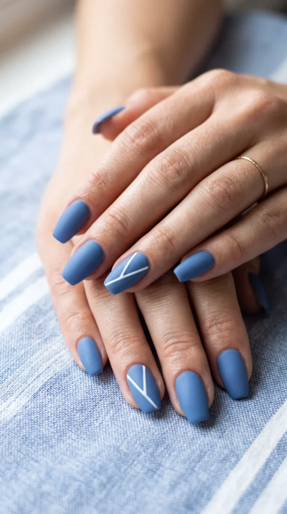 A person's hand with blue nail polish and a white triangle on the middle finger.