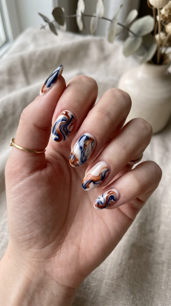 A woman with blue and orange nail polish on her fingers.