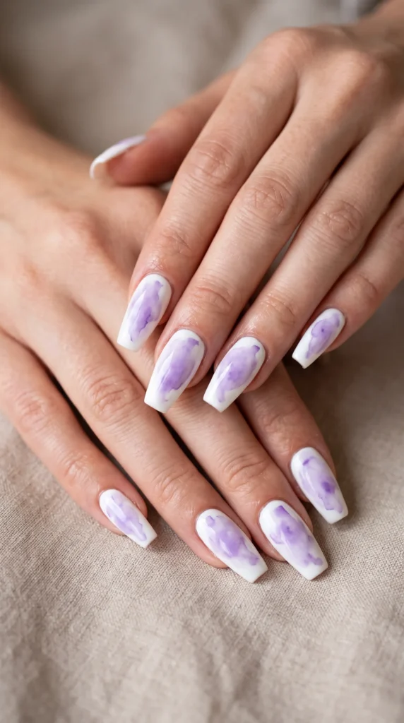 A person's hand with purple nail polish.
soft girl nails pink lavender peach