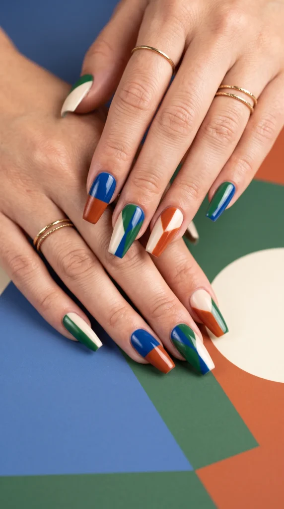 A hand with a green, white, and orange nail polish.