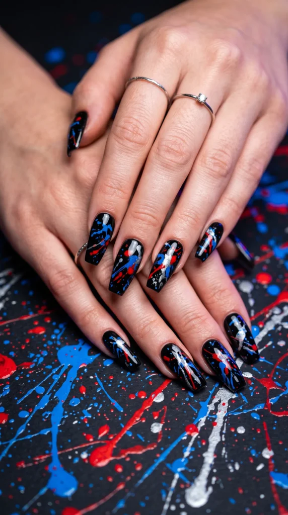 A person's hand with blue, red, and white nail polish.