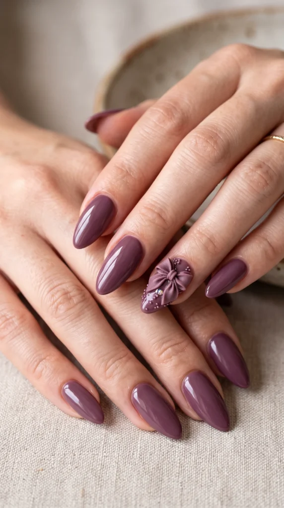 A woman with purple nail polish and a purple bow on her nail.