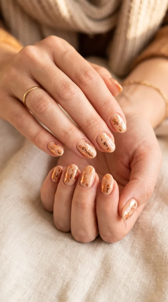 A person with a gold nail polish on their fingernails.