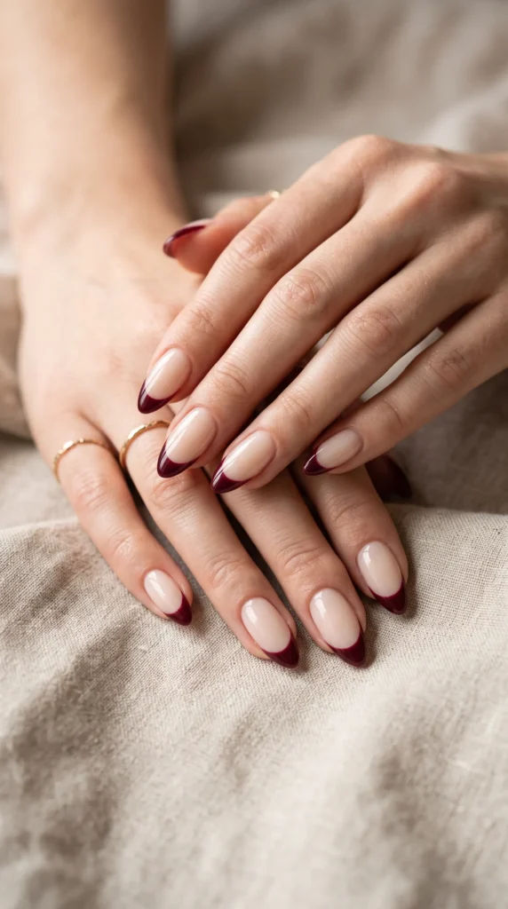 A woman with red nails and a gold ring on her finger.