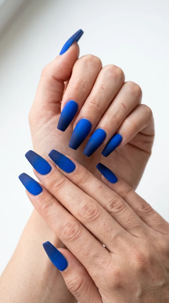 A person's hand with blue nail polish.