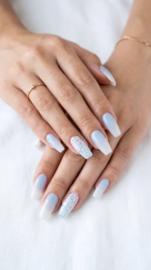 A woman's hands with blue nail polish and white designs on the nails.