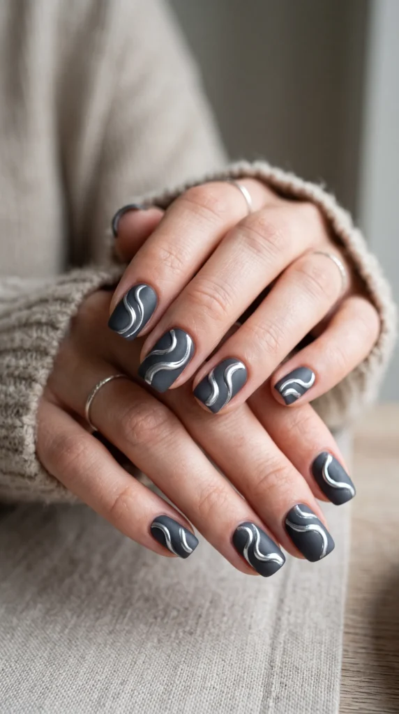 A woman with a grey and white nail polish on her fingers.