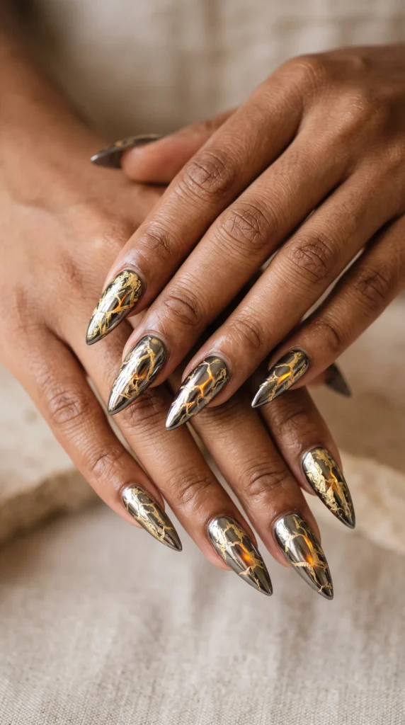 A woman with painted nails and a gold nail on her pinky finger.